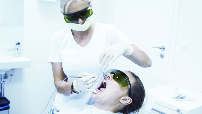 Dental hygenist cleaning teeth.